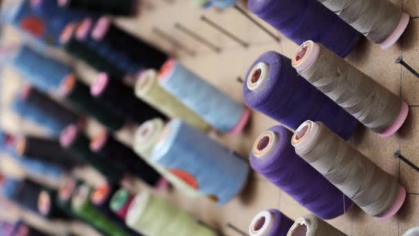 Close-up of multicolored threads in garment studio with blurred background — ストック動画