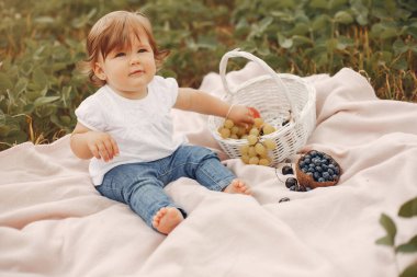 Parkta battaniyenin üzerinde oturan küçük şirin şey.