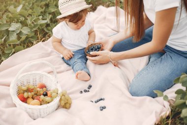 Anne ve kızı yaz tarlasında oynuyorlar.