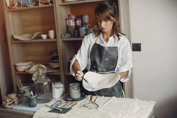 Μια νεαρή γυναίκα φτιάχνει πιάτα σε κεραμική — Φωτογραφία Αρχείου