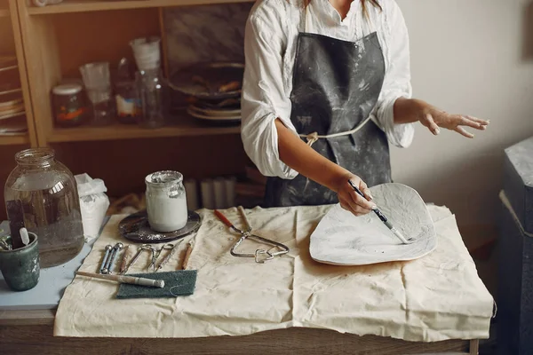 一个年轻的女人用陶器做饭 — 图库照片