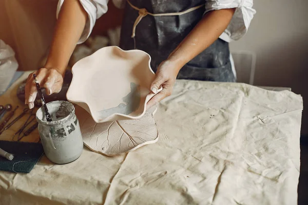 Молодая женщина готовит посуду в керамике — стоковое фото