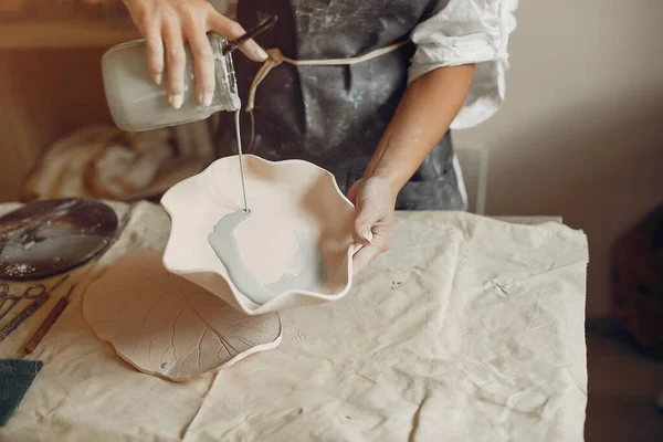 Une jeune femme fait des plats dans une poterie — Photo