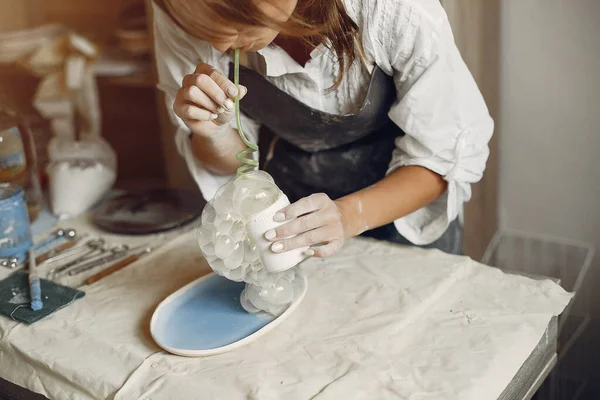 若い女性が陶器で料理を作る — ストック写真