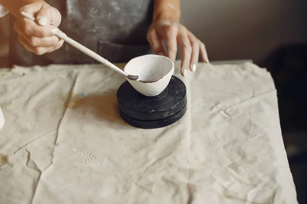 Une jeune femme fait des plats dans une poterie — Photo