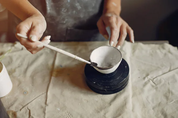 Μια νεαρή γυναίκα φτιάχνει πιάτα σε κεραμική — Φωτογραφία Αρχείου