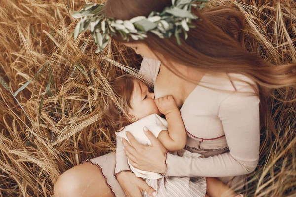 Elegante moeder met schattig dochtertje in een veld — Stockfoto