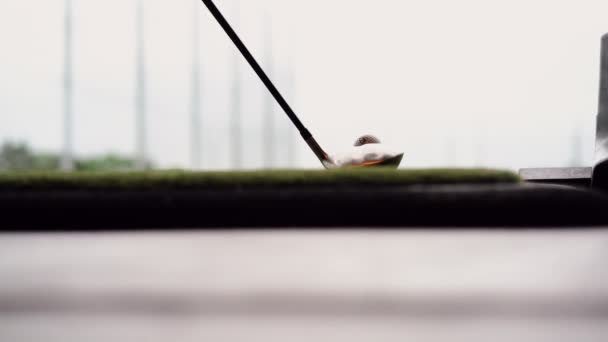 Close-up of golf ball on tee with golf club overlooking driving range at Topgolf — Stock Video