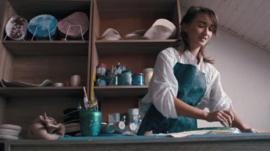 Çömlekçi mükemmel şekli elde etmek için bir şekil ve araçlar kullanarak bir çanak çömlek oluşturur.