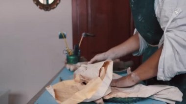 Çömlekçi mükemmel şekli elde etmek için bir şekil ve araçlar kullanarak bir çanak çömlek oluşturur.
