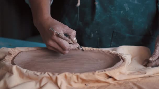 Pottenbakker vormen van klei in een schotel met behulp van een vorm en gereedschappen om de perfecte vorm te krijgen — Stockvideo