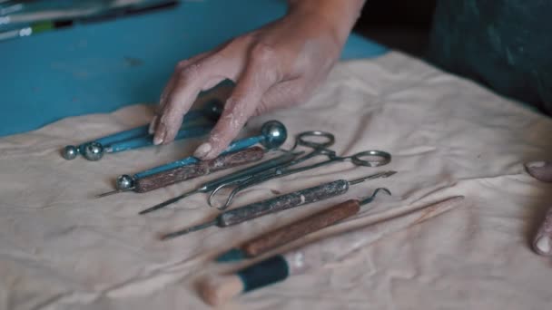 Artiste potier à la recherche du bon outil dans son atelier — Video