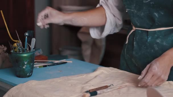Гончар ищет нужный инструмент в своей мастерской — стоковое видео