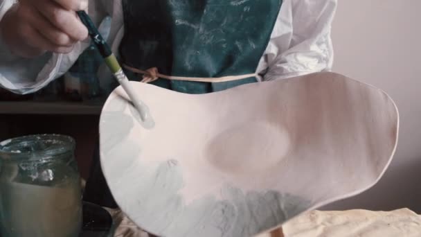 Vasaio professionista decorazione e pittura di un piatto dopo che lei ha cotto nel forno — Video Stock