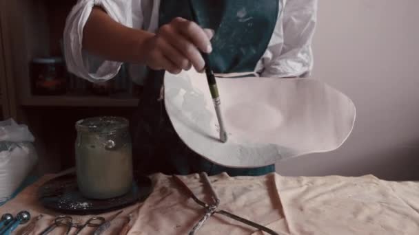 Vasaio professionista decorazione e pittura di un piatto dopo che lei ha cotto nel forno — Video Stock