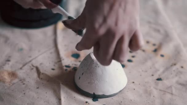 Professionele pottenbakker versieren en schilderen van een schotel nadat ze het heeft gebakken in de oven — Stockvideo