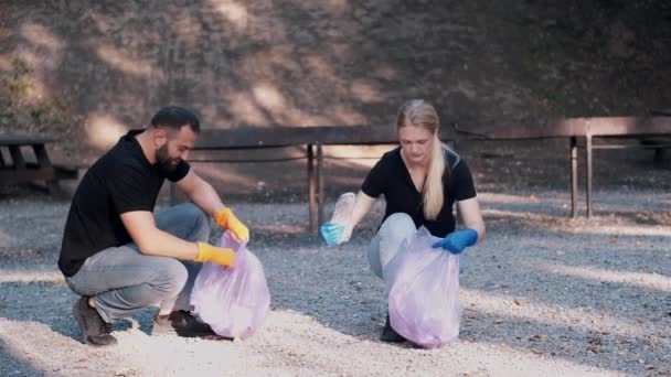 İki gönüllü hafta sonu etkinliği olarak halk parkında çöp topluyorlar. — Stok video