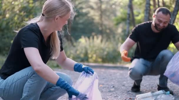 Két önkéntes szemetet gyűjt a közösségi parkban hétvégi tevékenységként. — Stock videók