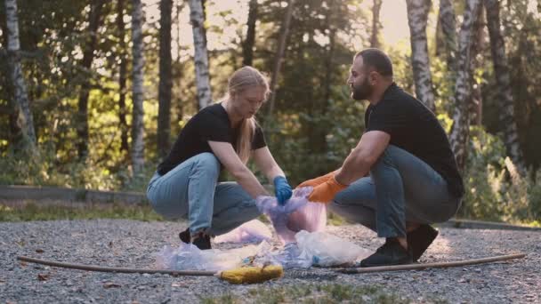 Två frivilliga plockar upp skräp och skräp i sin community park inte långt från sitt hem — Stockvideo