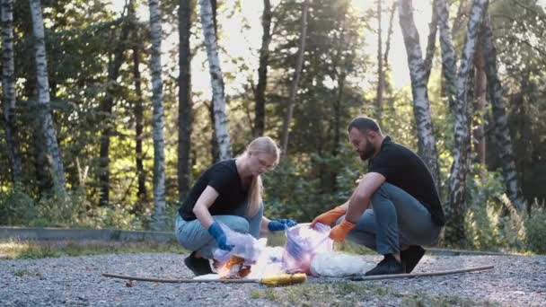 Två frivilliga plockar upp skräp och skräp i sin community park inte långt från sitt hem — Stockvideo