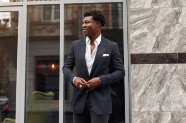 Sonbahar şehrinde siyah takım elbiseli bir zenci.