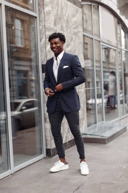 Sonbahar şehrinde siyah takım elbiseli bir zenci.