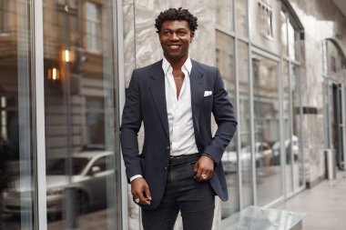 Sonbahar şehrinde siyah takım elbiseli bir zenci.