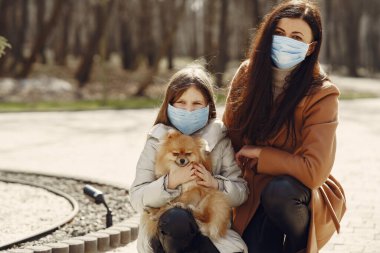 Anne ve kızı maskelerle dışarı çıkıyorlar.