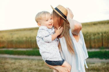 Anne ve oğlu yaz tarlasında oynuyorlar.