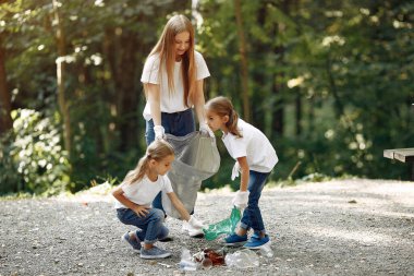 Çocuklar parktaki çöp torbalarında çöp topluyor.