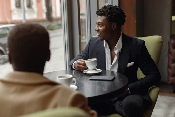 Schwarze Männer sitzen in einem Café und trinken einen Kaffee — Stockfoto