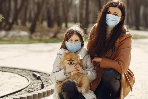 Madre con hija camina afuera con máscaras — Foto de Stock