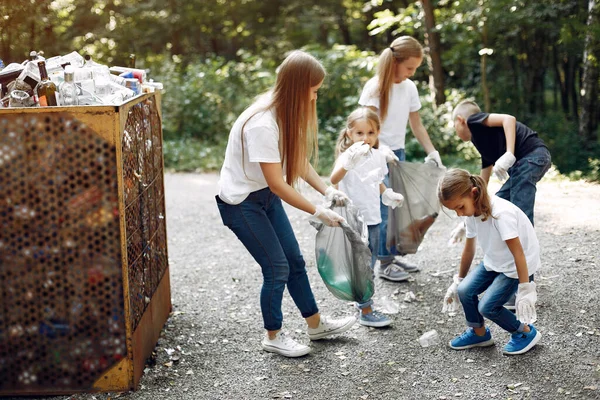 Crianças recolhem lixo em sacos de lixo no parque — Fotografia de Stock