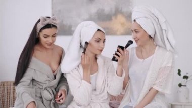 Havluya sarılı güzel kadınlar makyaj yapıyor.