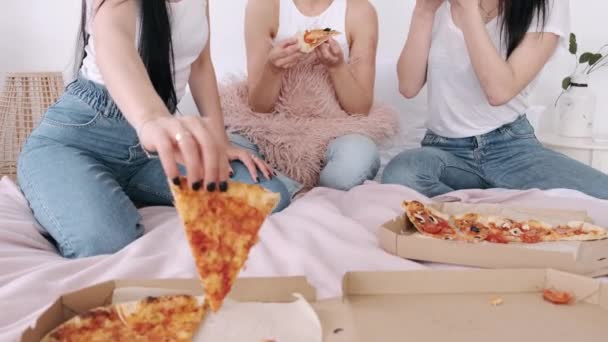 Close-up van cut takeaway pizza gedeeld door meisjes in het bed — Stockvideo