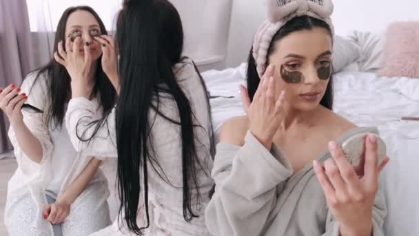Schöne Damen setzen Pflaster auf ihre Gesichter — Stockvideo