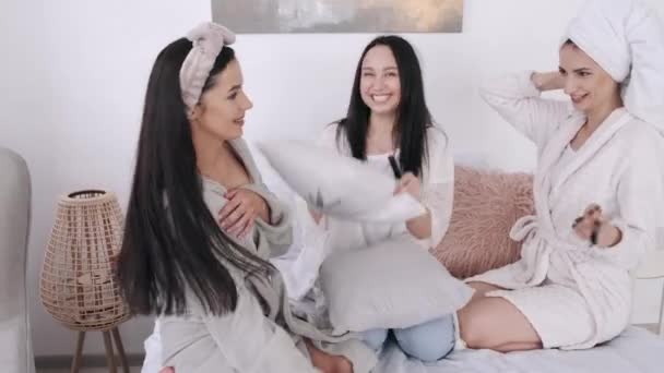 Jonge mooie vrouwen zitten op het bed met make-up borstels en glimlachen — Stockvideo