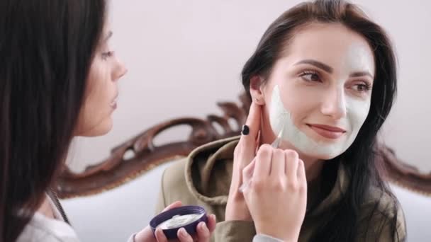 Женщина надевает маску на лицо своих друзей — стоковое видео