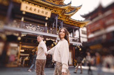 Yeni evli çift Çin 'i ziyaret ederken Şangay' da el ele tutuşuyorlar.