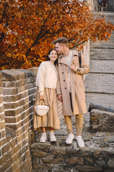 young couple kissing at the Great Wall of China