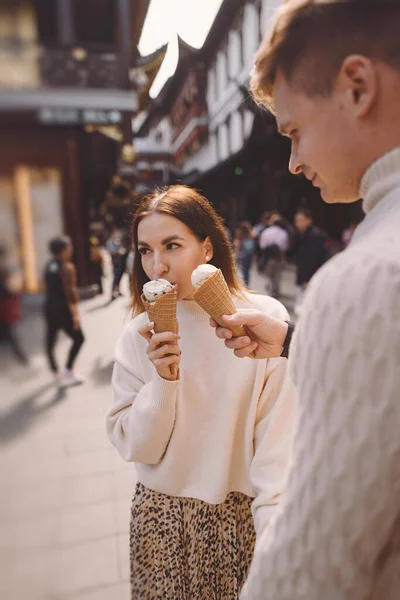 Newlywed couple eating ice cream from a cone on a street in Shanghai near Yuyuan China. — Stock Photo, Image