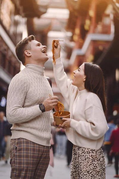 Pareja recién casada comiendo fideos con palillos en Shanghai fuera de un mercado de alimentos —  Fotos de Stock