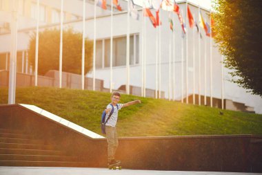 Sırt çantalı ve kaykaylı bir öğrenci.