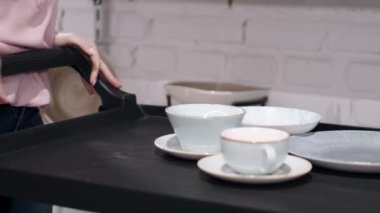 Alışveriş arabasında tabakları olan porselen bardakların yakın görüntüsü.