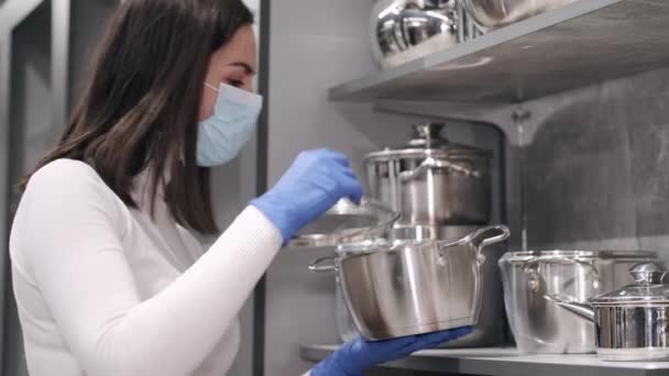 La femme en gants de caoutchouc et masque vérifie les casseroles — Video
