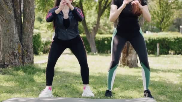 Zwei hübsche junge Frauen trainieren im Park — Stockvideo