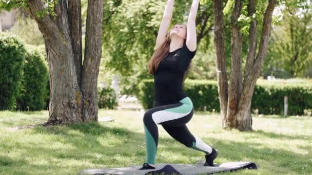 Mulher europeia bonita está se esticando lá fora no parque — Vídeo de Stock