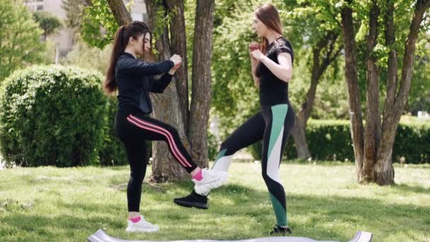 Zwei europäische Athletinnen führen den Challenge Dance im Park auf — Stockvideo