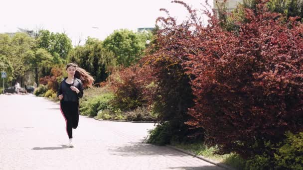Mulher atlética bonita está correndo ao ar livre — Vídeo de Stock