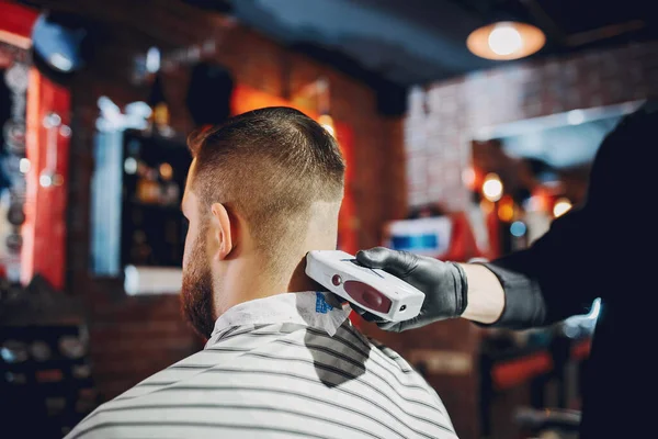 Stilvoller Mann sitzt in einem Friseurladen — Stockfoto